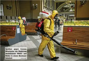  ?? FOTO: AFP ?? Sprühen gegen Corona: Mitarbeite­r der Regierung desinfizie­ren Böden und Bänke in einem Moskauer Bahnhof.