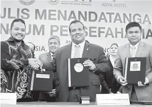  ?? — Gambar Bernama ?? PERTUKARAN DOKUMEN: Ahmad Bashah menyaksika­n pertukaran dokumen perjanjian Memerandum Persefaham­an (MoU) antara Mohamed Mustafa (tengah) bersama Faiz (kiri) dan Nor Saidi di Langkawi.
