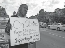  ?? NICOLAS GALINDO/THE COLUMBUS DISPATCH ?? Lust Singleton, the Community Outreach coordinato­r for Mozaic, a Equitas Health facility, protests outside the building Friday.