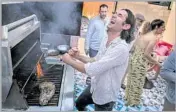  ??  ?? DIEGO Caivano grills chicken and skirt steak for a Sunday dinner crowd at his hillside Silver Lake home.