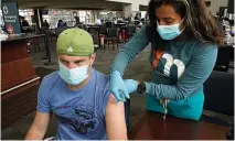  ?? AP photo by Steven Senne ?? Q Kevin Fisher, of Quincy, Mass., left, receives his second shot of Moderna COVID-19 vaccine May 19 from RN Katherine Francisco of Avon, Mass., right, at a mass vaccinatio­n clinic at Gillette Stadium in Foxborough, Mass.