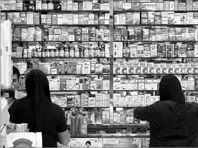  ?? AFP ?? Customers buy goods in an independen­t pharmacy in Hong Kong. The World Health Organizati­on estimates that as many as half of all medicines are inappropri­ately prescribed, dispensed or sold, which can lead to health problems.