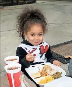  ?? Photos by Noah Syverson, Rome News-Tribune ?? LEFT: Heavenly Nicholson, 3, enjoys her Thanksgivi­ng dinner.