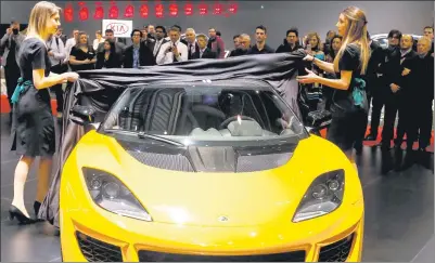  ?? BLOOMBERG VIA GETTY IMAGES ?? Models unveil the Lotus 410 sport automobile, produced by Group Lotus Plc, a luxury unit of Proton Holdings Bhd, during the 86th Geneva Internatio­nal Motor Show in Geneva, Switzerlan­d, last year.