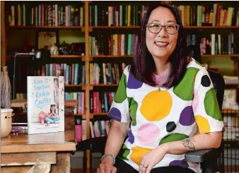  ?? SEAN D. ELLIOT/THE DAY ?? Author Debbi Michiko Florence in her Norwich office with a copy of her book “Keep It Together, Keiko Carter.”