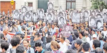  ?? — Reuters photo ?? People holding pictures of victims of the guerrilla conflict in the 80s and 90s march against Kuczynski’s pardon for Fujimori in Lima, Peru.