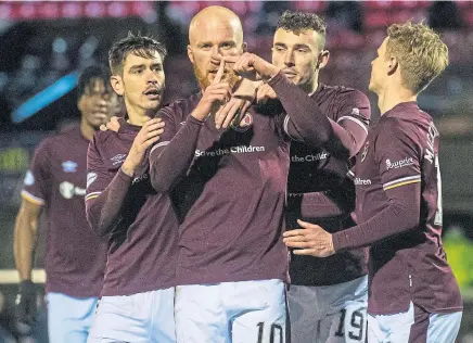  ??  ?? Teammates crowd Liam Boyce after he had converted a penalty to claim the three points against Ayr United