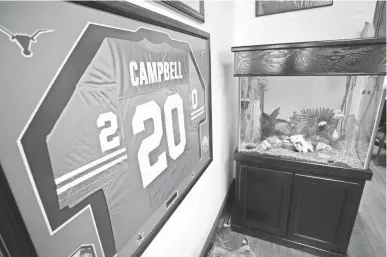  ?? ERICH SCHLEGEL, USA TODAY SPORTS ?? A framed No. 20 University of Texas jersey adorns a wall at Earl Campbell’s home in Austin. He won the 1977 Heisman Trophy in his senior season with the Longhorns.