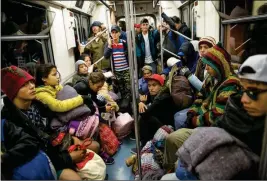  ?? ASSOCIATED PRESS ?? CENTRAL AMERICAN MIGRANTS RIDE ON THE SUBWAY after leaving the temporary shelter at the Jesus Martinez stadium, in Mexico City on Friday. About 500 Central American migrants headed out of Mexico City on Friday to embark on the longest and most dangerous leg of their journey to the U.S. border, while thousands more were waiting one day more at the stadium.