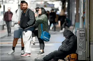  ?? CHRIS MCKEEN/ STUFF ?? A homeless person sleeps on top of their belongings in Queen St in Auckland.
