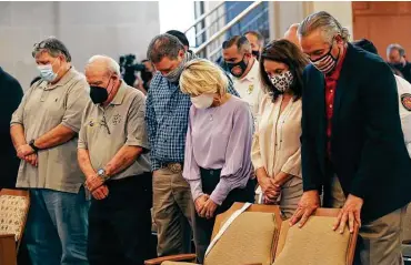  ?? Photos by Jerry Lara / Staff photograph­er ?? First responders sent to Ground Zero after 9/11 pray with their wives during a ceremony in City Council chambers. From left are René M. Garcia Jr., Dennis Meier, Shane and Tiffany George, and Velma and Frank Willborn.