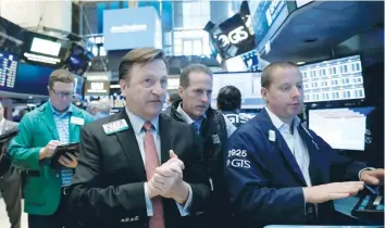  ?? — Reuters ?? Traders work on the floor of the New York Stock Exchange (NYSE) in New York.