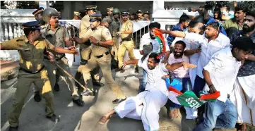  ??  ?? A police officer wields his stick against the members of Kerala Students Union (KSU), the student wing of India’s main opposition Congress party, outside a police station during a protest in Kochi, India. — Reuters photo