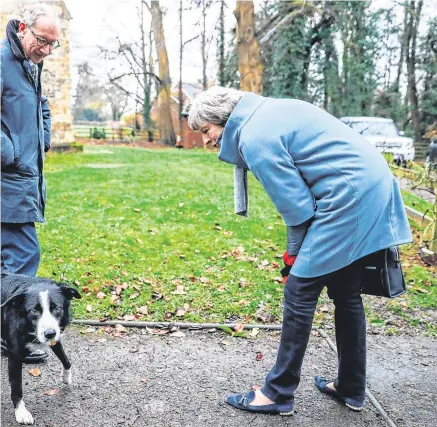  ?? PHOTO: PA WIRE ?? Dogged mentality: Prime Minister Theresa May and husband Philip interact with border collie Blitz as they leave church yesterday.