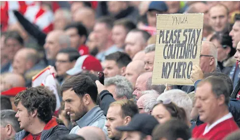  ??  ?? A Liverpool fan holds up a placard in support of Philippe Coutinho during a recent match.