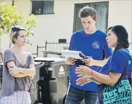  ??  ?? ECHO PARK resident Shannon Ashcraft, left, listens to Scott Tripamer and Mendoza of PETA. The group regularly fields emergency calls from Angelenos.