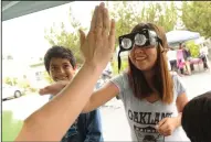  ?? BEA AHBECK/NEWS-SENTINEL ?? Dulce Mendoza tries to give a high-five to Jamie Henderson of the World of Wonders Science Museum as Kevin Acosta watches during the 2014 Celebratio­n on Central.