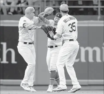  ?? Victor Decolongon Getty Images ?? CENTER FIELDER Alex Verdugo, middle, celebrates with left fielder Joc Pederson, left, and right fielder Cody Bellinger after making a diving catch for the final out in the Dodgers’ 3-2 victory over the Chicago Cubs.