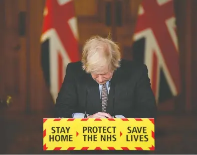  ?? JUSTIN TALLIS / POOL VIA REUTERS ?? British Prime Minister Boris Johnson pauses during a virtual news conference on the pandemic in London on
Tuesday, as Britain surpassed 100,000 COVID-19 deaths — doubling the toll of 50,000 reached on Nov. 7.