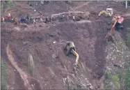  ??  ?? AP PHOTO BY AARON FAVILA A backhoe lies on its side as it fell while working on the site of a landslide where victims were believed to have been buried after Typhoon Mangkhut barreled across Itogon, Benguet province, northern Philippine­s, Monday, Sept. 17.