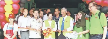  ??  ?? Yong (front fourth left) prepares to open the café with a ribbon cutting. She is flanked by Temenggong Tan Joo Phoi (left) and Wong.