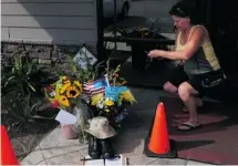  ?? Tyler Tjomsland/the Spokesman-review/the Associated Press ?? Lill Duncan takes a photo of a memorial for Delbert Belton, an 88-year-old who was beaten to death, in Spokane, Wash.