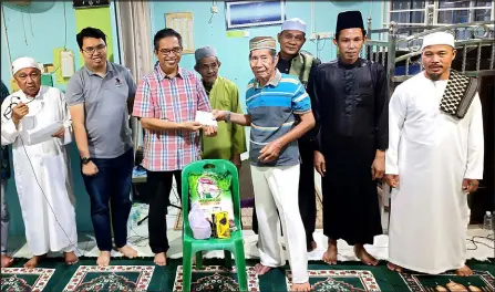  ?? ?? Kamil (third left) presents the donation to an elderly villager, Bosong Sabang, as (from left) Abdul Kadir, Rizwan, Akop, Kassim, Mohd Hafiz and Abdullah Sham look on.