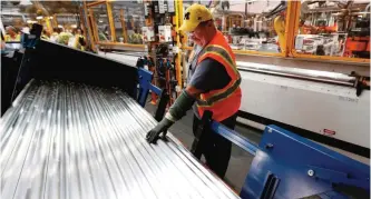  ??  ?? DEARBORN: Tom Peters looks at material for roof rails on the production line for the 2015 Ford F-150 at the Dearborn Truck Plant in Dearborn, Michigan. The Institute for Supply Management reported on a survey about US manufactur­ing production and...