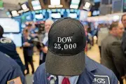  ?? [AP PHOTOS] ?? A stock trader wears a Dow 25,000 hat Thursday at the New York Stock Exchange. The Dow Jones industrial average closed above 25,000 points for the first time, just five weeks after its first close above 24,000.