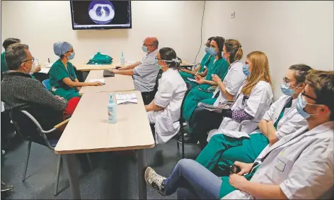  ??  ?? Michel Slama (left), Amiens Hospital ICU deputy head, and medical workers of the covid-19 unit attend a daily meeting in the Amiens Picardie hospital.