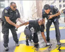  ??  ?? ‘EPIC’: Bevelyn Beatty smears paint on the BLM mural in Midtown — before doing the same in Harlem and Brooklyn.