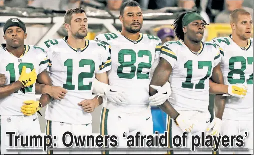  ??  ?? LEADER OF THE PACK: Green Bay Packers quarterbac­k Aaron Rodgers (No. 12) and teammates lock arms during Thursday’s anthem.