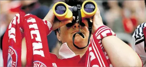  ?? DPA-BILD: SCHRADER ?? Wo sind sie denn? Ein Fan des FC Bayern schaut durch ein Fernglas – echte Verfolger sind nicht in Sicht.
