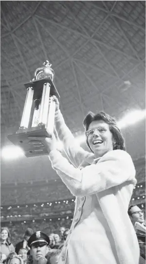  ?? Associated Press file ?? In this Sept. 20, 1973, file photo, Billie Jean King holds the winner’s trophy high after defeating Bobby Riggs in the $100,000 winner-take-all tennis match at the Astrodome in Houston. But did that match really change anything in sports?