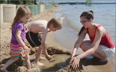  ?? GARY NYLANDER/Okanagan Weekend ?? Amanada Lemay of Kelowna and her kids, Makaylee, 3, left and Levi, 6, play in the sand at City Park on Thursday. Some parks with beaches are still closed due to high lake levels.