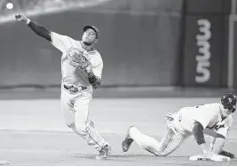  ?? FRANK FRANKLIN II/AP ?? Marlins shortstop Adeiny Hechavarri­a tries to throw out Mets pitcher Bartolo Colon at first base after forcing out Anthony Recker in the third inning.