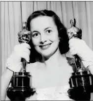  ?? (AP file photo) ?? Actress Olivia de Havilland holds her Oscar statues in this March 24, 1950, file photo. De Havilland won for her performanc­e that year in “The Heiress,” and in “To Each His Own” in 1946.