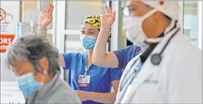  ?? Charles Krupa The Associated Press ?? Health care workers wave Wednesday to a departing patient, who recovered after being stricken with COVID-19, in Nashua, N.H.