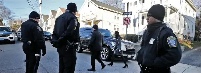  ?? NANCY LANE / HERALD STAFF FILE ?? HEARD LOCALLY: Mayor Michelle Wu walks down her driveway, looked after by Boston police officers as protesters rally outside her house on March 30.