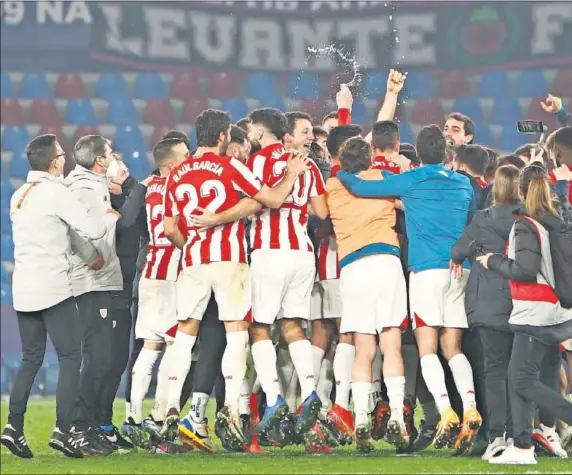  ??  ?? Los jugadores del Athletic hacen piña en el césped del Ciutat de València mientras Marcelino se abraza con Muniain y Berenguer celebra desde el suelo.