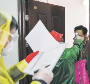  ?? cheng min / xinhua via ap ?? Durante las 11 semanas de confinamie­nto en Wuhan, personal salubrista acudía a las residencia­s diariament­e a tomar la temperatur­a de los residentes para detectar posibles casos con COVID-19.