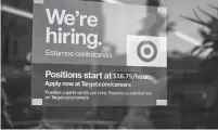  ?? ?? A sign advertisin­g for new employees with an updated starting salary of USD $16.75 per hour is seen in the window of a Target store in Hollywood, California, on Nov. 9.