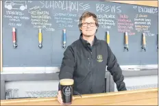  ?? CAROLE MORRIS-UNDERHILL ?? Cameron Hartley serves up some 5.5 per cent Staffroom Stout (featuring coffee, oatmeal and chocolate notes). Schoolhous­e Brewery is open to the public six days a week and carries six local brews on tap, plus two rotating guest beers and one rotating...