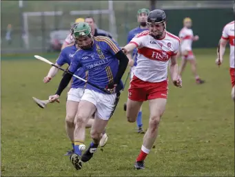  ??  ?? Derry’s Eamon Kearns loses his hurl as John Henderson drives forward.