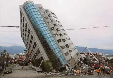  ?? REUTERS PIC ?? Rescue workers near a damaged building yesterday, after an earthquake hit Hualien, Taiwan.