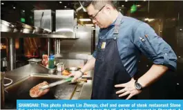  ??  ?? SHANGHAI: This photo shows Lin Zhengu, chef and owner of steak restaurant Stone Sal, cooking a piece of beef imported from the US, at his restaurant in Shanghai. A key objective of President Donald Trump’s trade war is to pressure Beijing to “buy American”, but when it comes to millions of dollars of US meat imports, China may simply take its business elsewhere. — AFP