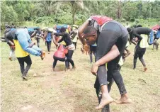  ?? ?? Members of Uganda’s Soft Ground Wrestling carry fellow fighters as they take part in a training session at their camp in Mukono.