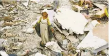  ??  ?? A statue of the Blessed Virgin Mary stands amid the ruins of the former home of Annmarie Klein and her family in Washington, Ill.