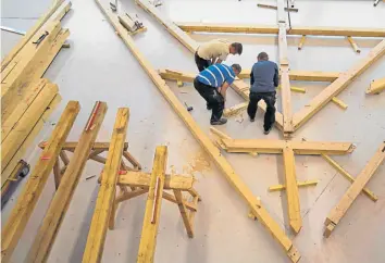  ??  ?? • Carpintero­s trabajan en una armadura de techo que coincide con una de la Catedral.