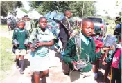  ?? ?? Schoolchil­dren carry trees during the launch of a model children’s green park by the country’s Environmen­tal patron First Lady Dr Auxillia Mnangagwa in Glen Norah, Harare, yesterday
